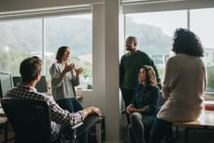 Diverse designers discussing a project together in their office while standing and sitting casually