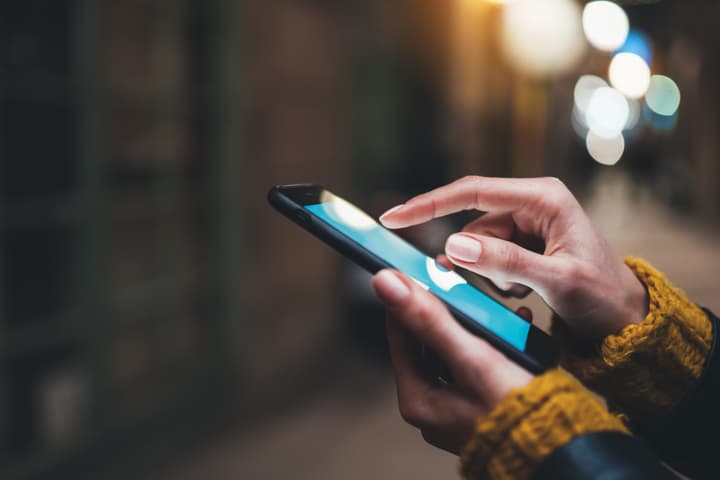 Close up of a woman texting on a smart phone.