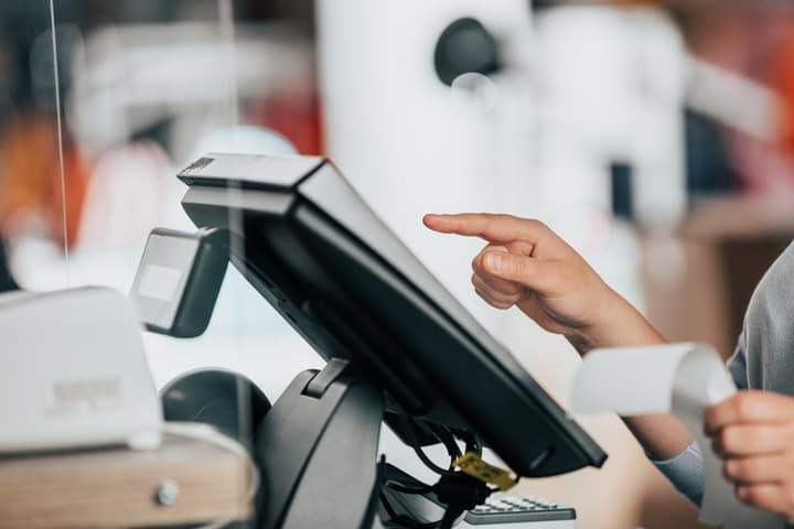 A woman uses a touchscreen interface on an electronic point of sale system.