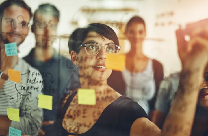 Cropped shot of a group of young designers using sticky notes during a brainstorming session.