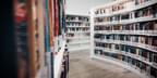 A view of books on large, white bookshelves in a modern library