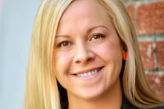 A portrait of Propeller's former Change Management Director, Rachel Crocker Boyl. She wears a dark grey blazer over a black, button-up blouse.